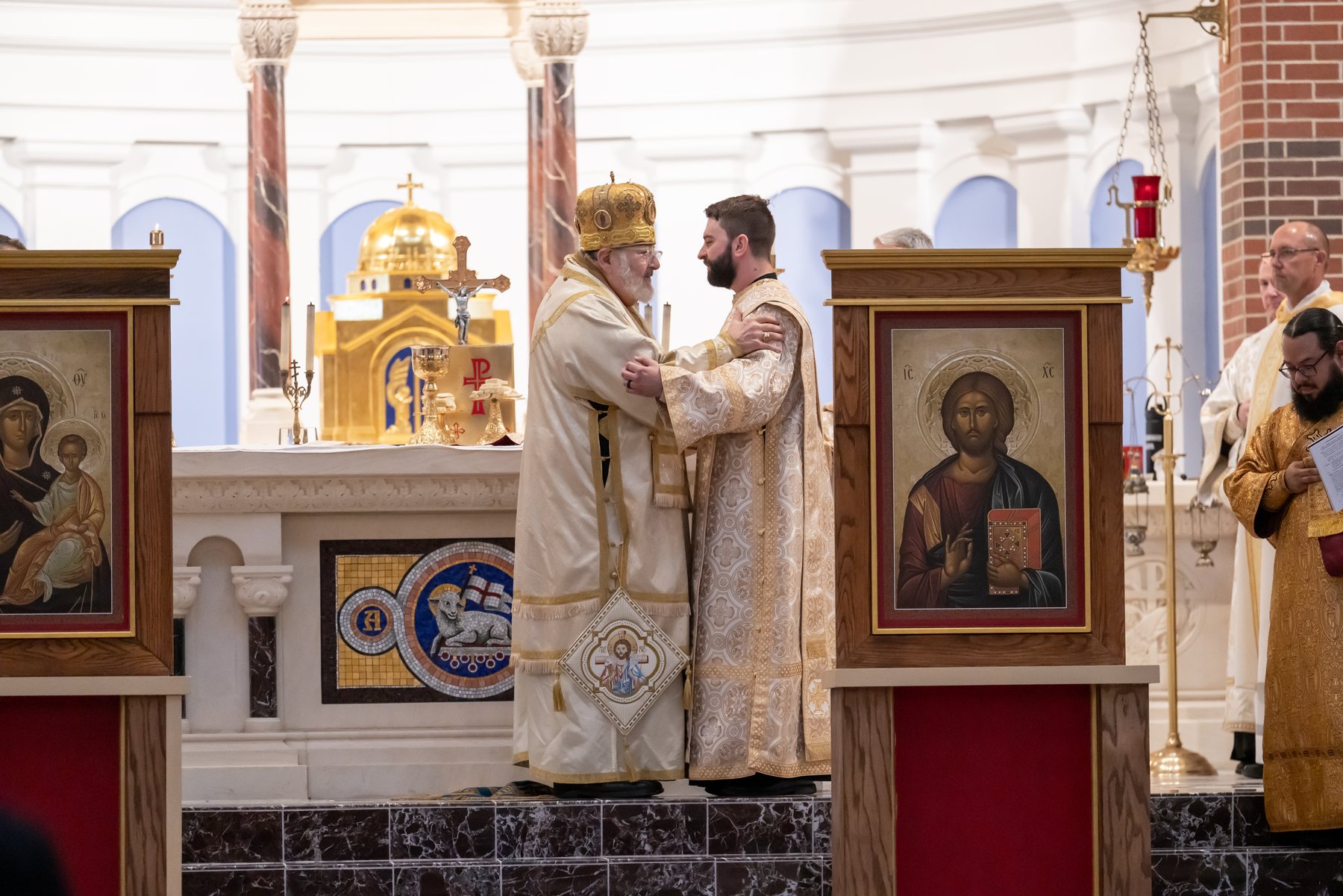 Bishop John Michael Botean embraces the newly ordained deacon at St. Mary's Catholic Church